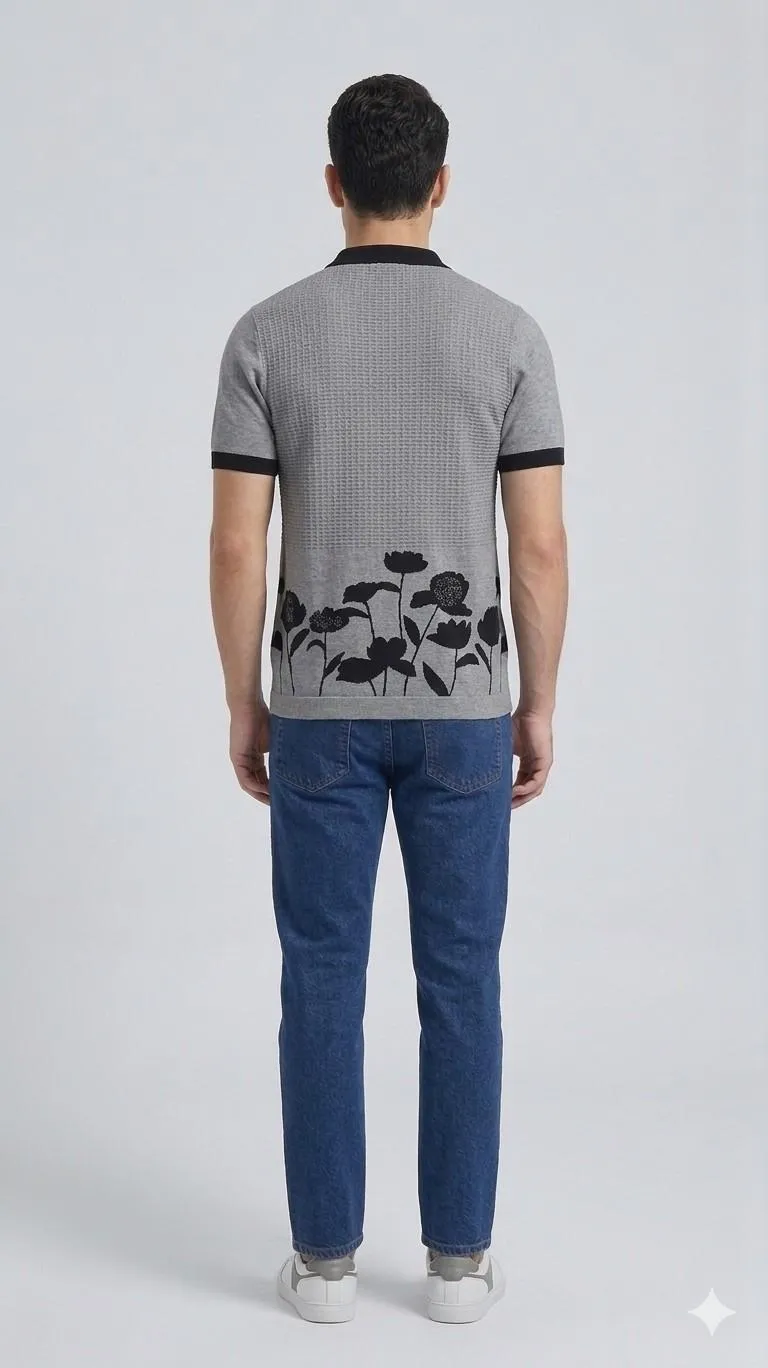 A men standing facing back in relaxed posture wearing gray half sleeve collar t-shirt and wearing jeans.