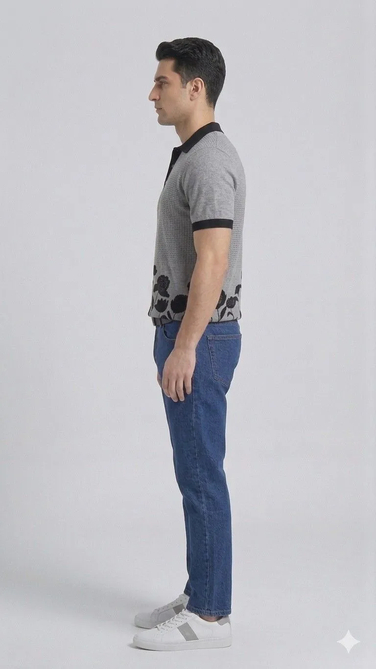 A men standing right direction in relaxed posture wearing gray half sleeve collar t-shirt and wearing jeans.